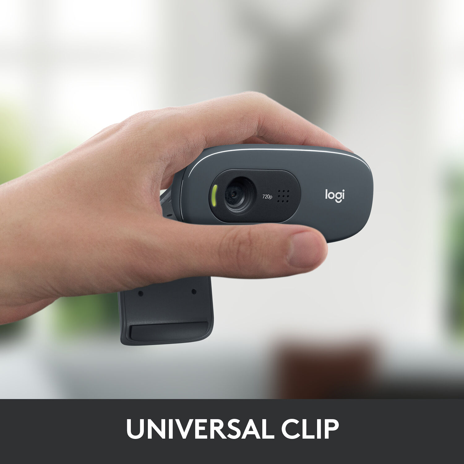 Logitech C270 HD webcam held in hand showing universal clip mount and front view