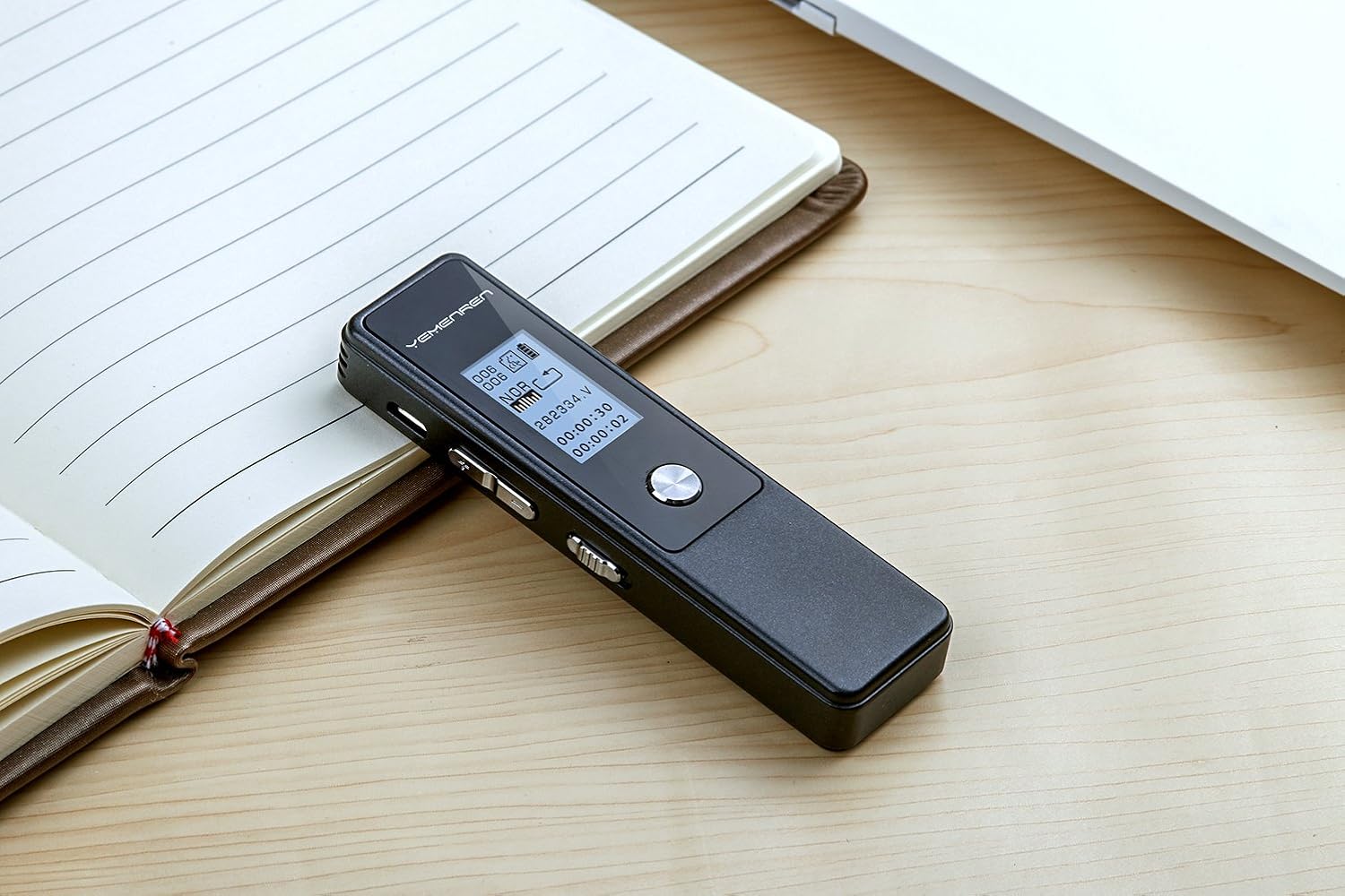 Yemenren voice recorder lying on an open notebook on a desk